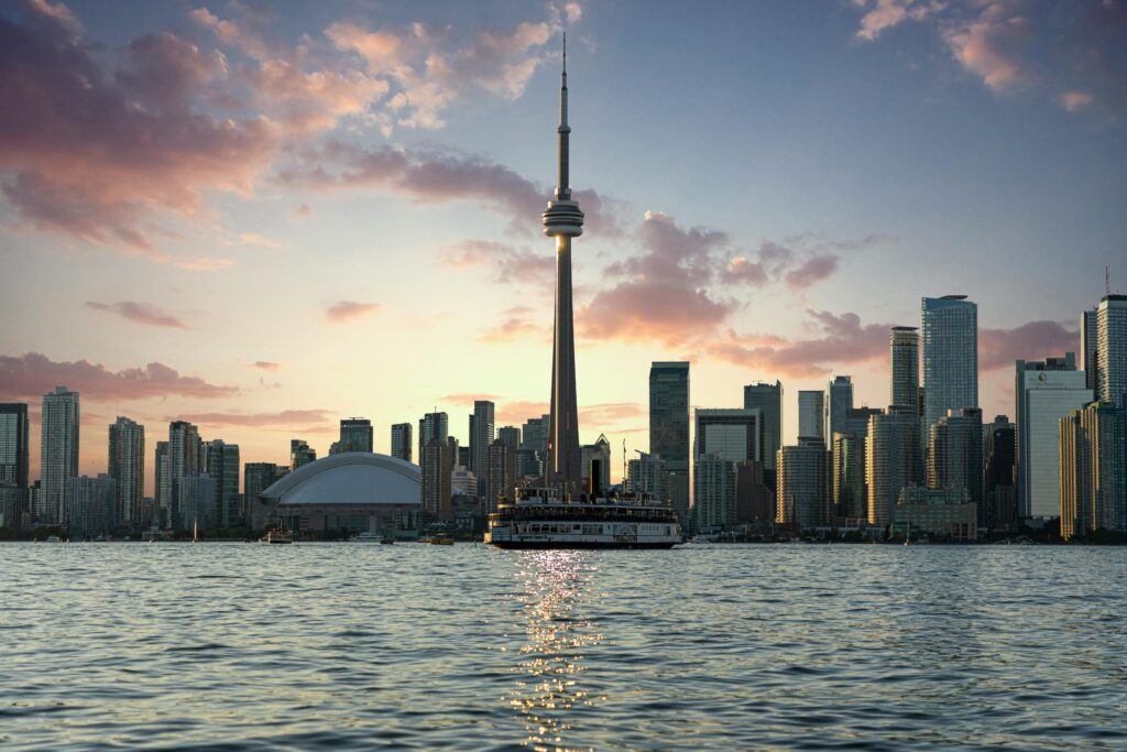 Stunning Toronto skyline at sunset, highlighting the CN Tower and waterfront from Lake Ontario.